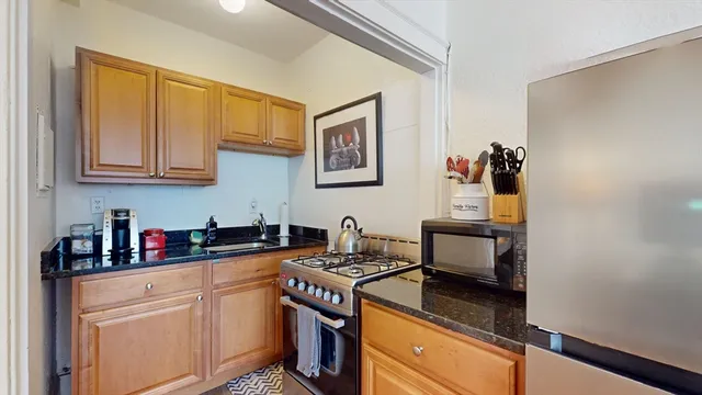 a kitchen with stainless steel appliances granite countertop a sink stove and cabinets