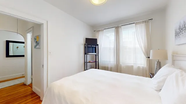 a bedroom with a bed and a large mirror