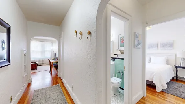 a view of a bedroom with a bed and wooden floor