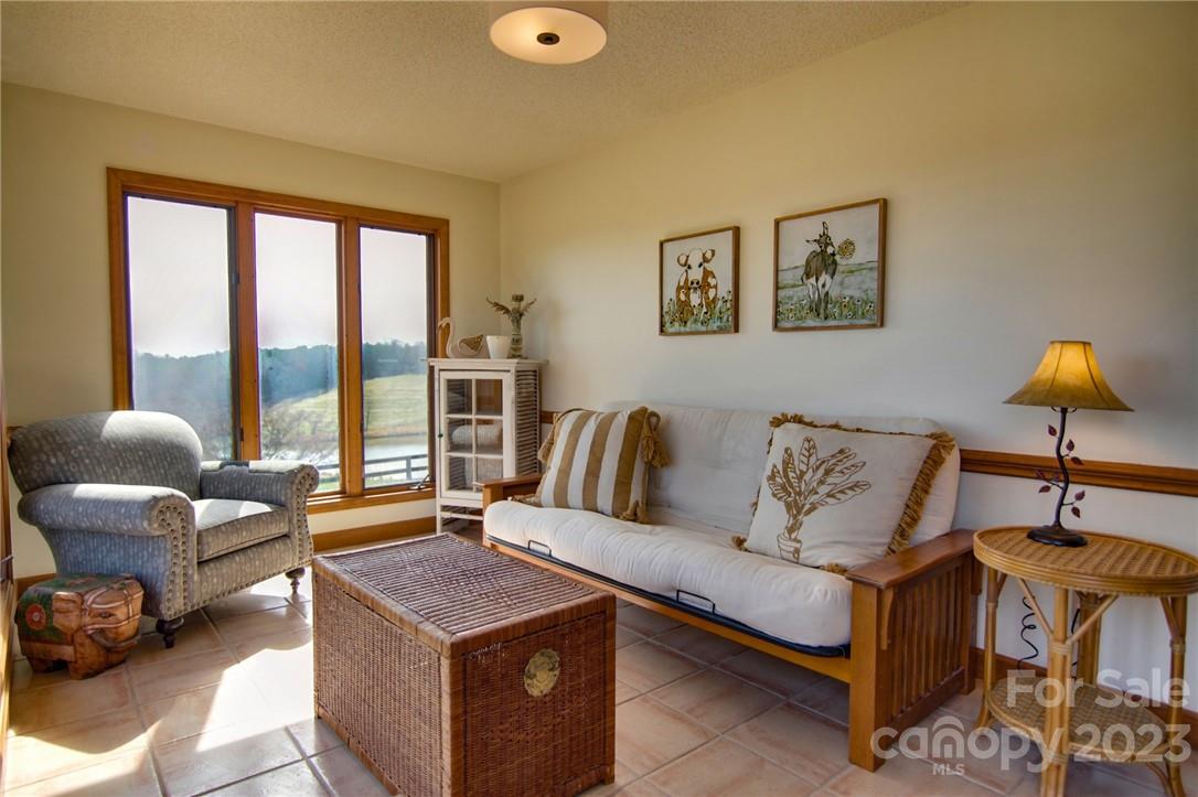 7100 Highway 108 Mill Spring, NC 28756 - Photo 20 of 48 a living room with furniture and a floor to ceiling window