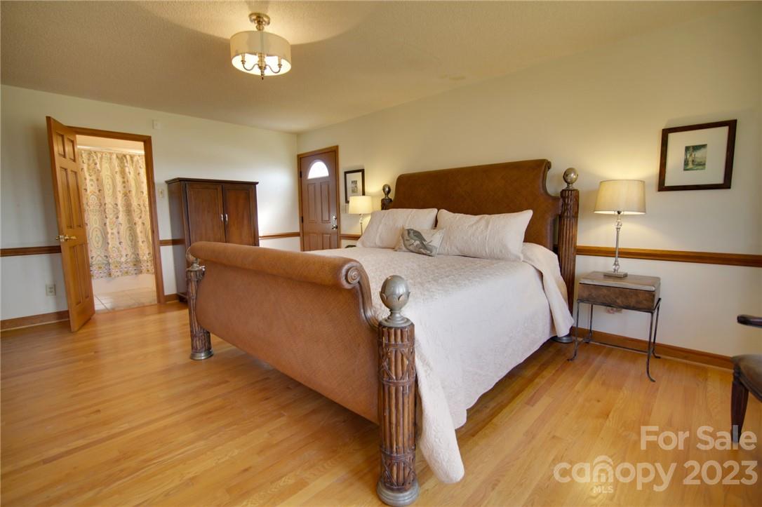 7100 Highway 108 Mill Spring, NC 28756 - Photo 27 of 48 a bedroom with a bed and a chandelier