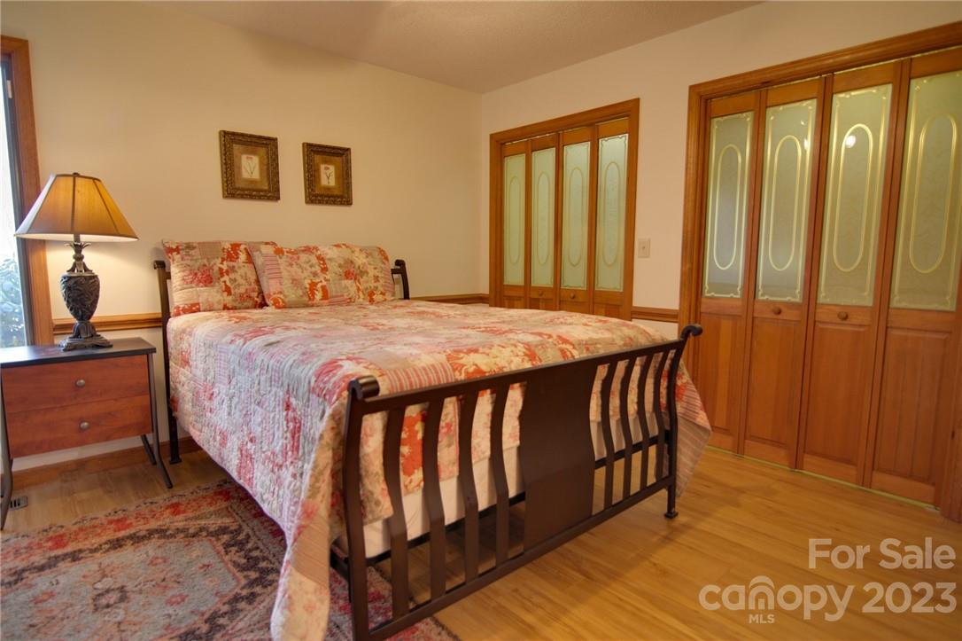 7100 Highway 108 Mill Spring, NC 28756 - Photo 29 of 48 a bedroom with a bed and wooden floor