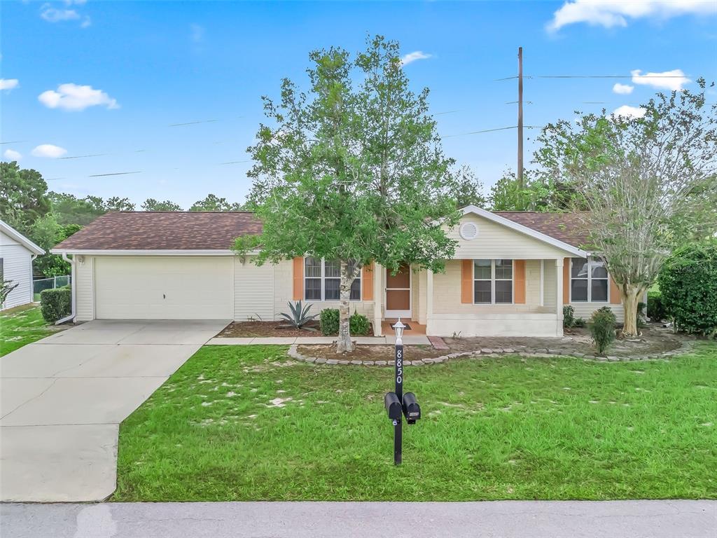 8850 Southwest 116th Place Road Ocala, FL 34481 - Photo 2 of 53 a front view of house with a garden and trees