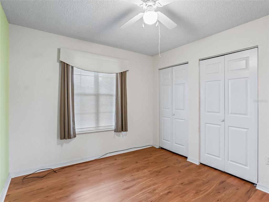 8850 Southwest 116th Place Road Ocala, FL 34481 - Photo 24 of 53 an empty room with wooden floor chandelier fan and windows