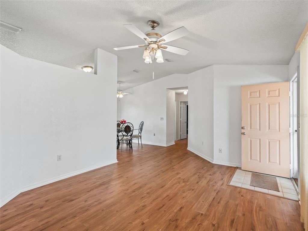 8850 Southwest 116th Place Road Ocala, FL 34481 - Photo 7 of 53 an empty room with wooden floor fan and windows