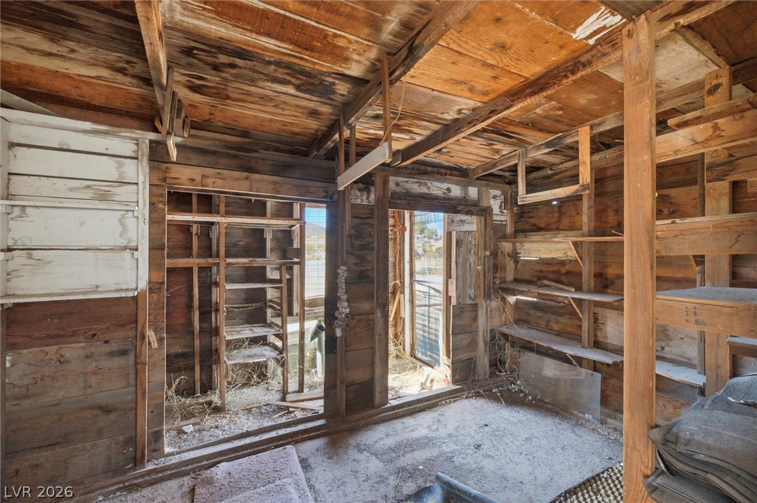 405 Main Street Beatty, NV 89003 - Photo 26 of 28 A rustic interior space awaits transformation, featuring exposed wood paneling and shelving units.