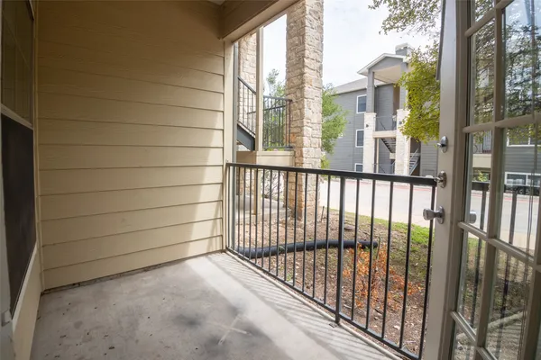 a view of a balcony with a floor to ceiling window next to a brick wall