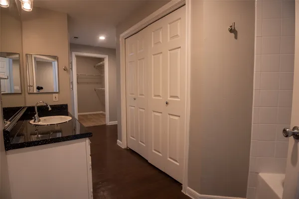a bathroom with a granite countertop sink a mirror and a shower