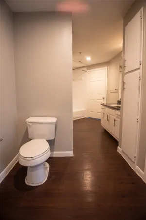 a bathroom with a toilet and a refrigerator