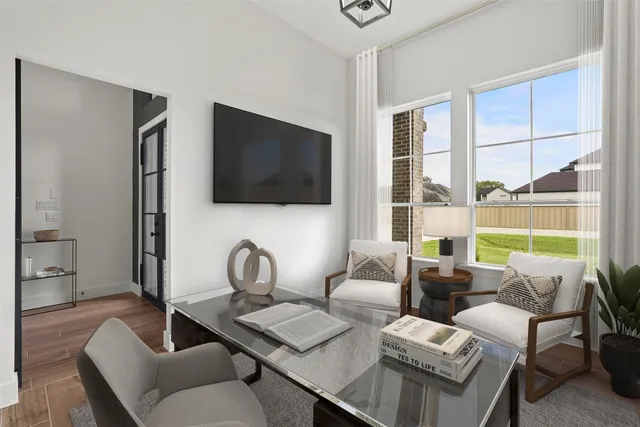 a living room with furniture a flat screen tv and a window