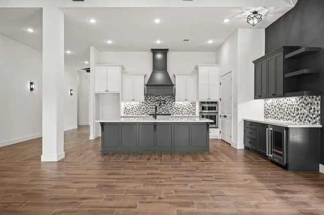 a large kitchen with stainless steel appliances kitchen island granite countertop a stove and a refrigerator