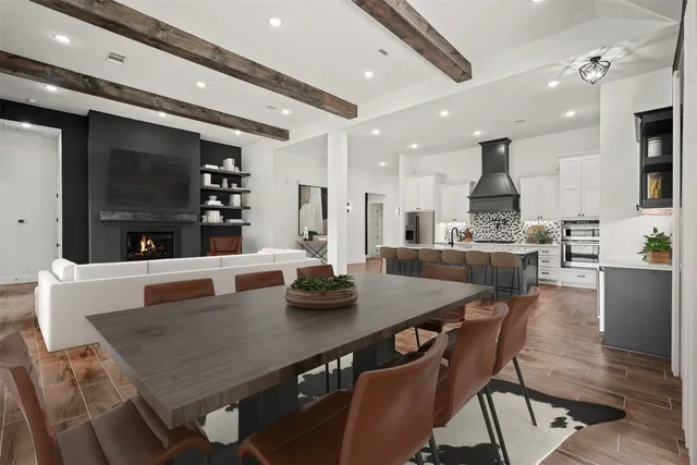 a kitchen with stainless steel appliances kitchen island granite countertop a dining table chairs and view living room