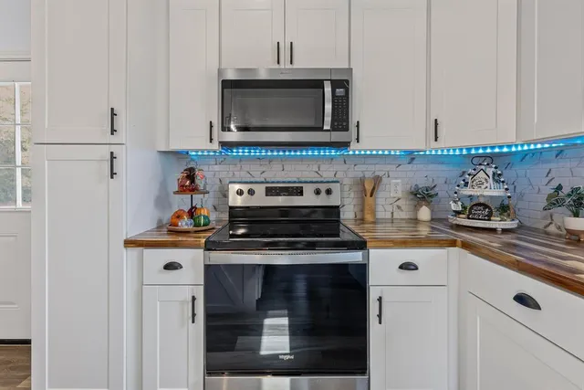 a kitchen with stainless steel appliances granite countertop a stove a microwave and cabinets