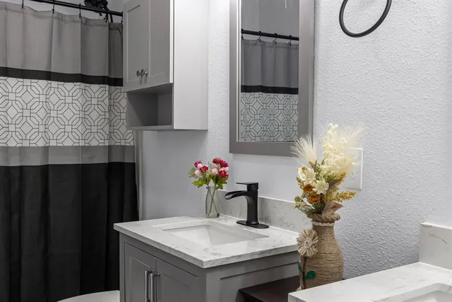 a bathroom with a sink vanity granite and a mirror
