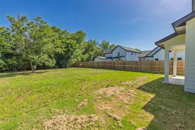 a view of swimming pool with lawn chairs and large trees