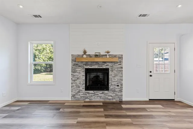 a view of a livingroom with wooden floor and a fireplace