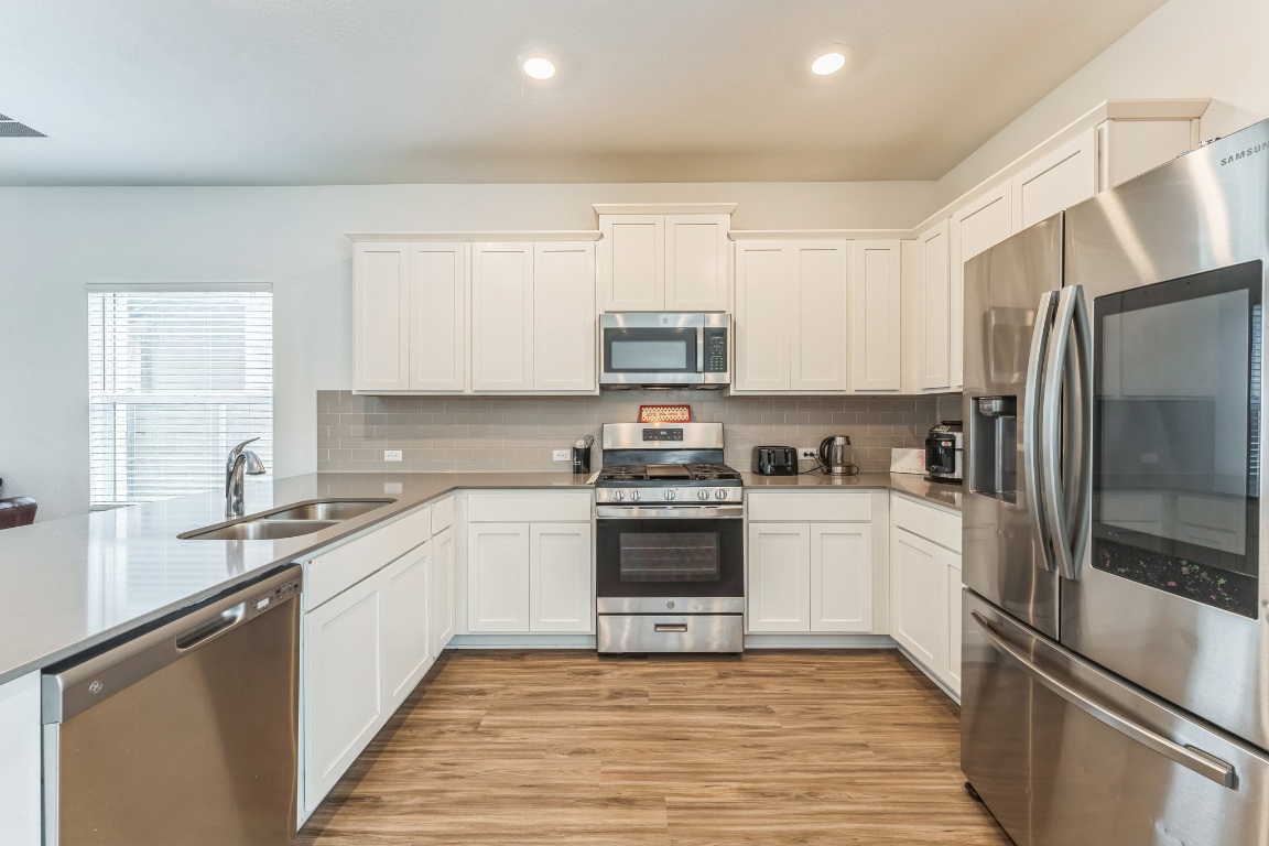 133 Cherry Ridge Road Georgetown, TX 78628 - Photo 13 of 30 a kitchen with stainless steel appliances granite countertop a stove top oven a refrigerator and a sink