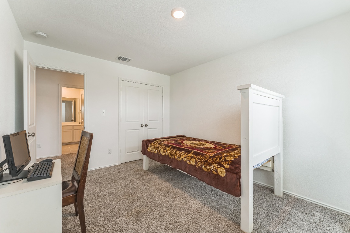 133 Cherry Ridge Road Georgetown, TX 78628 - Photo 19 of 30 a bedroom with a bed and a chair