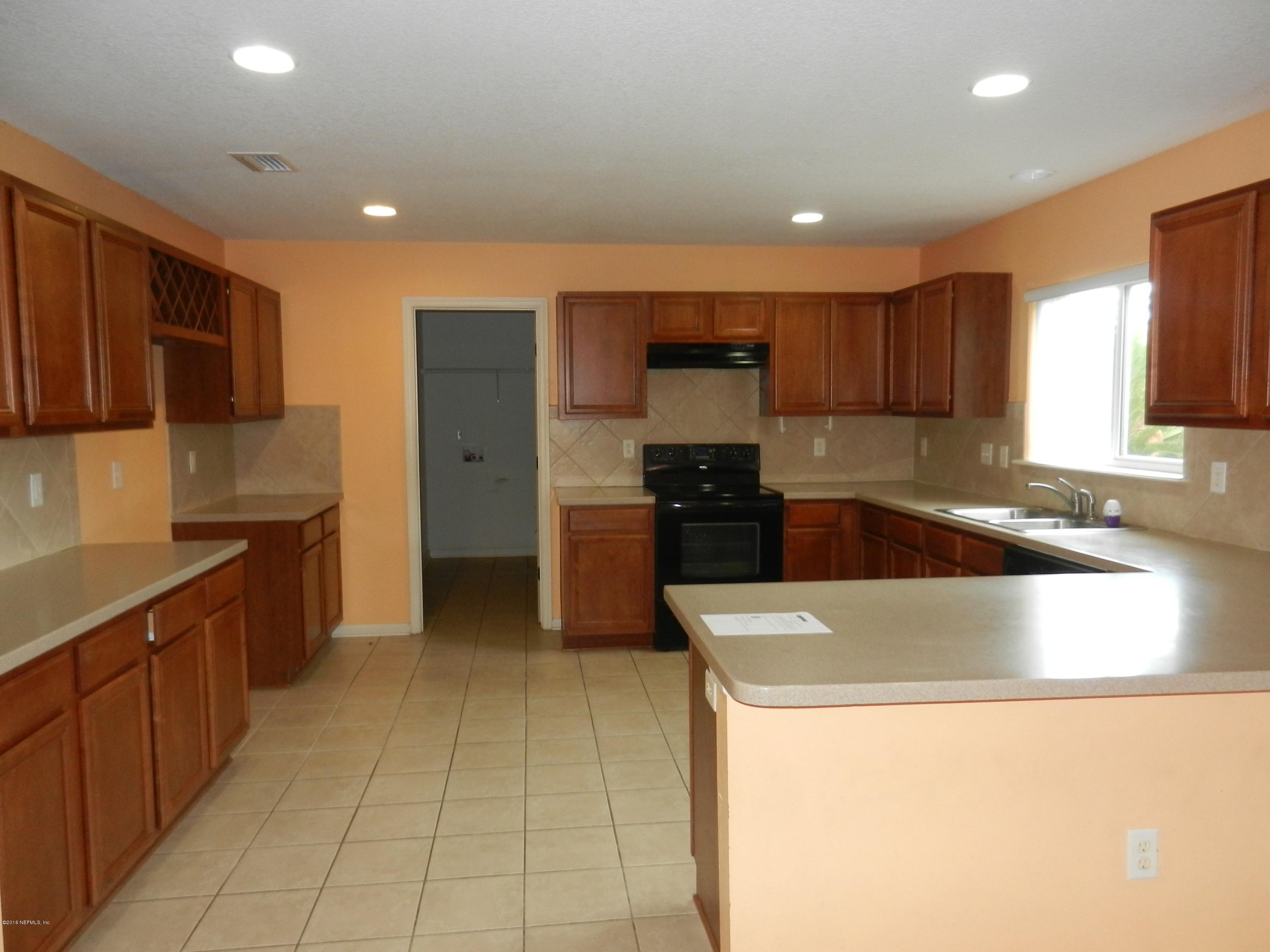 86339 Cartesian Pointe Drive Yulee, FL 32097 - Photo 2 of 21 a kitchen with stainless steel appliances a sink a stove a microwave a sink a refrigerator and cabinets