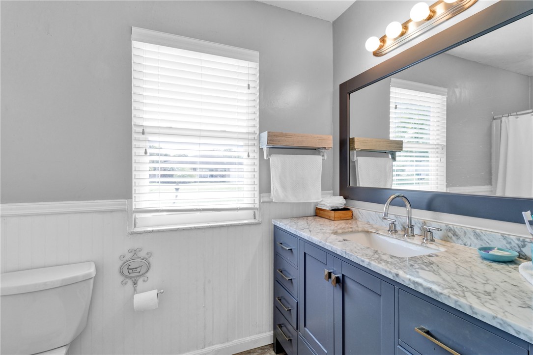 202 Delaware Avenue Sebastian, FL 32958 - Photo 15 of 34 a bathroom with a granite countertop sink a toilet a mirror and a window