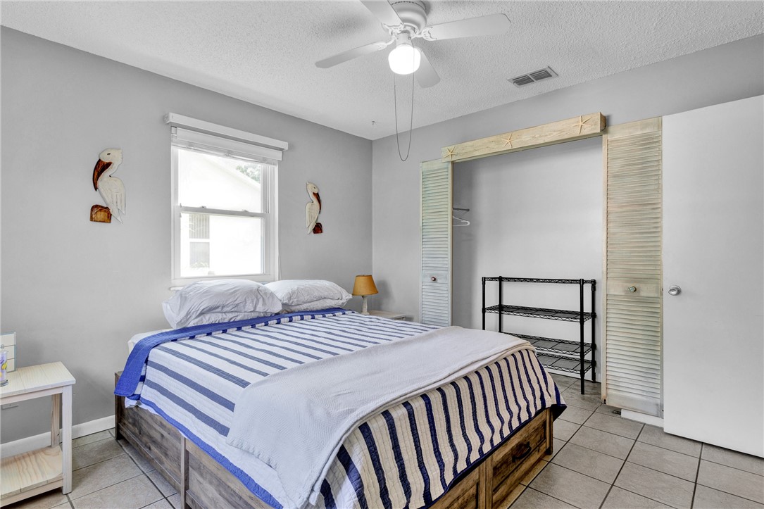 202 Delaware Avenue Sebastian, FL 32958 - Photo 18 of 34 a bedroom with a bed and a chandelier