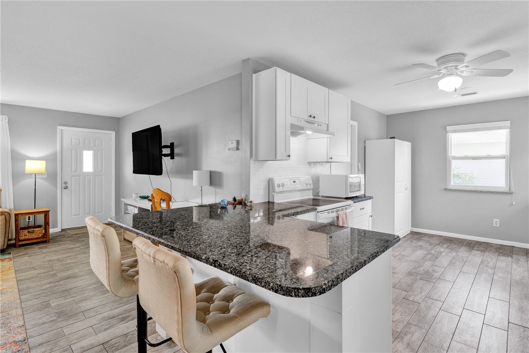 202 Delaware Avenue Sebastian, FL 32958 - Photo 8 of 34 a kitchen with stainless steel appliances granite countertop a sink dishwasher and a stove with wooden floor