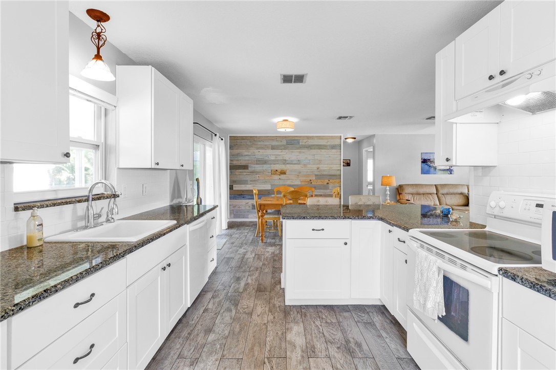 202 Delaware Avenue Sebastian, FL 32958 - Photo 10 of 34 a large white kitchen with a lot of counter space and wooden floor