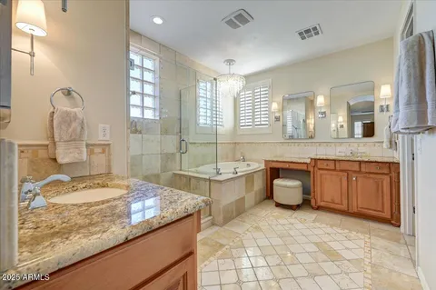 a spacious bathroom with a granite countertop sink a mirror and a bathtub