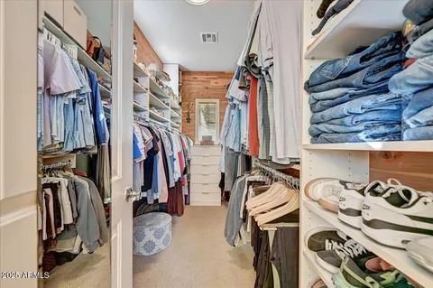 a view of walk in closet with clothes and shoes