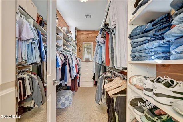 a view of walk in closet with clothes and shoes