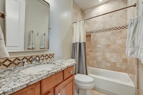a bathroom with a granite countertop sink toilet and shower