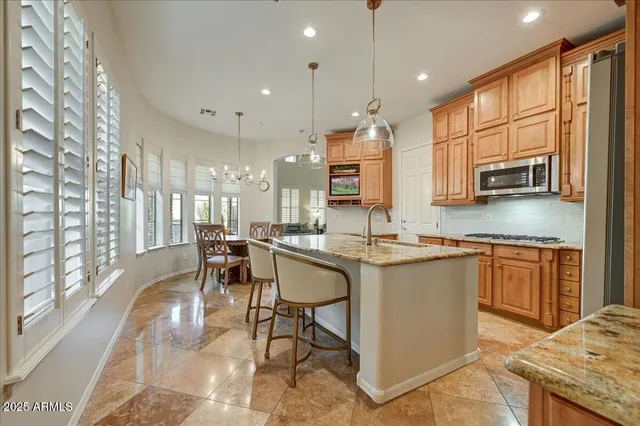 a kitchen with stainless steel appliances granite countertop sink stove top oven and cabinets