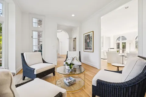 a view of a hallway with wooden floor and a potted plant