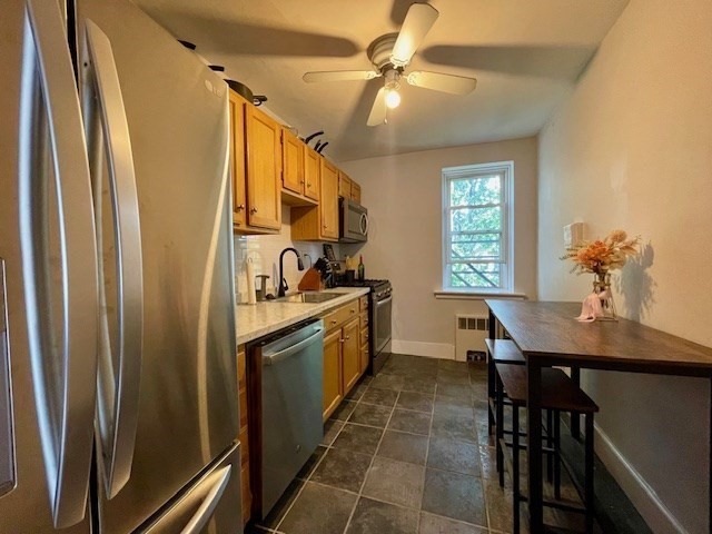 125 Farragut Road, Unit 46 Boston, MA 02127 - Photo 2 of 15 a kitchen with stainless steel appliances granite countertop a refrigerator a sink dishwasher a stove and a dining table with wooden floor