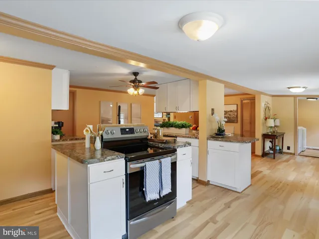 a kitchen with granite countertop a sink cabinets and wooden floor