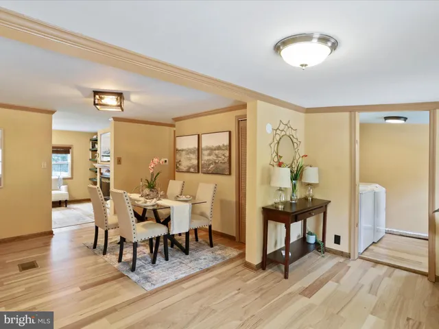 a view of a dining room with furniture a kitchen and chandelier