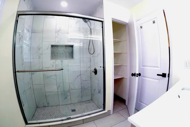 a bathroom with a shower and a mirror