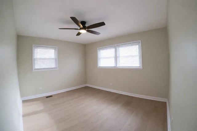 a view of a big room with wooden floor closet and windows