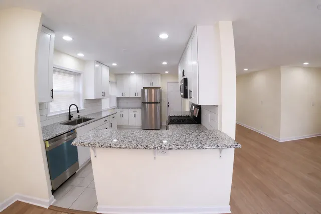 a kitchen with stainless steel appliances granite countertop a sink stove and refrigerator