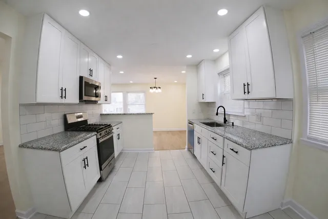 a large kitchen with stainless steel appliances granite countertop a stove a sink and a granite counter tops