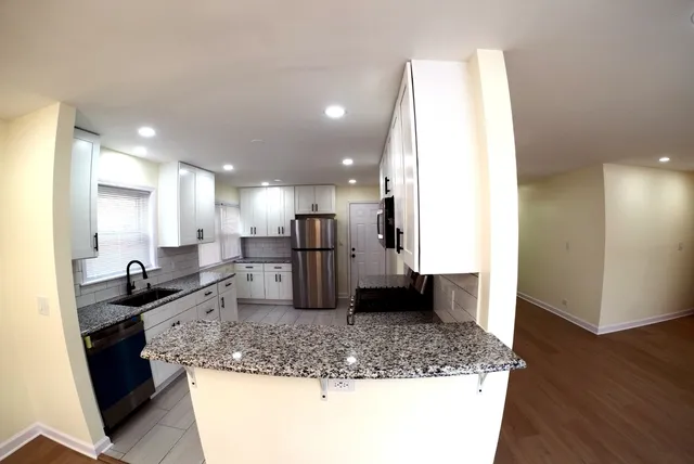 a kitchen with stainless steel appliances granite countertop a sink stove and refrigerator