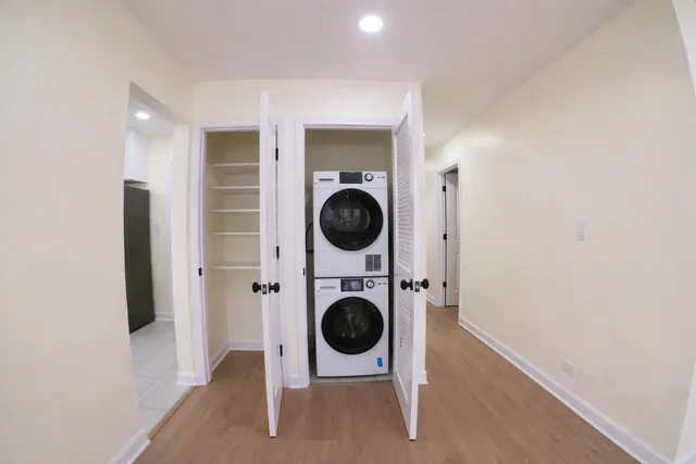 a room with wooden floor washing machine and dryer