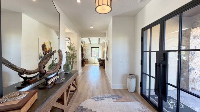 168 South Rancho Santa Fe Virgin, UT 84779 - Photo 7 of 58 Expansive entryway featuring light wood-finish flooring, a contemporary black-framed glass door, recessed lighting, and a decorative ceiling fixture