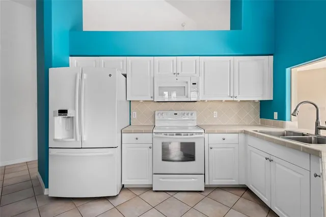 a view of a kitchen with white cabinets and entryway