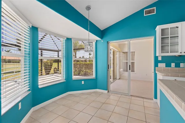 a kitchen with a stove a sink and a refrigerator with white cabinets