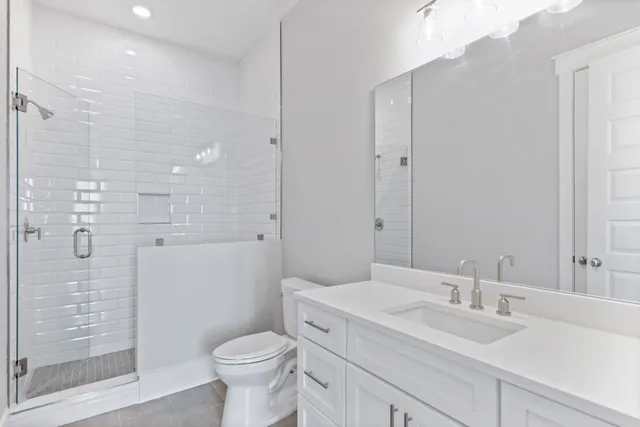 a kitchen with stainless steel appliances granite countertop a refrigerator a sink dishwasher a stove and white countertops with wooden floor