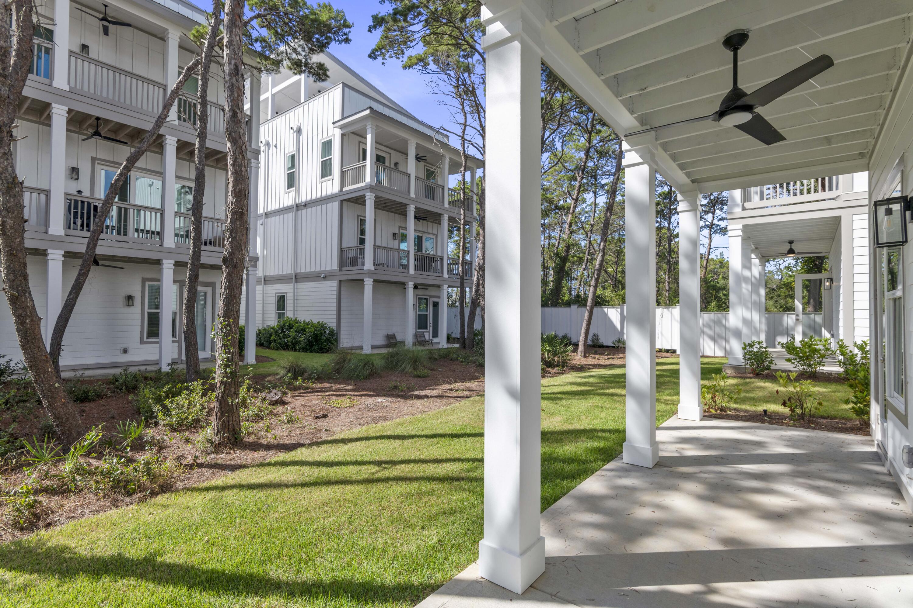 21 West Queen Palm Dr Inlet Beach Inlet Beach, FL 32461 - Photo 21 of 85 a backyard of a house with a fountain and a large tree