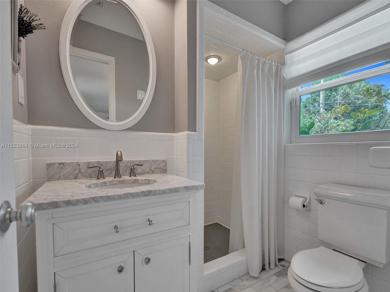 3445 Fillmore Street Hollywood, FL 33021 - Photo 28 of 76 a bathroom with a granite countertop toilet a sink and a mirror