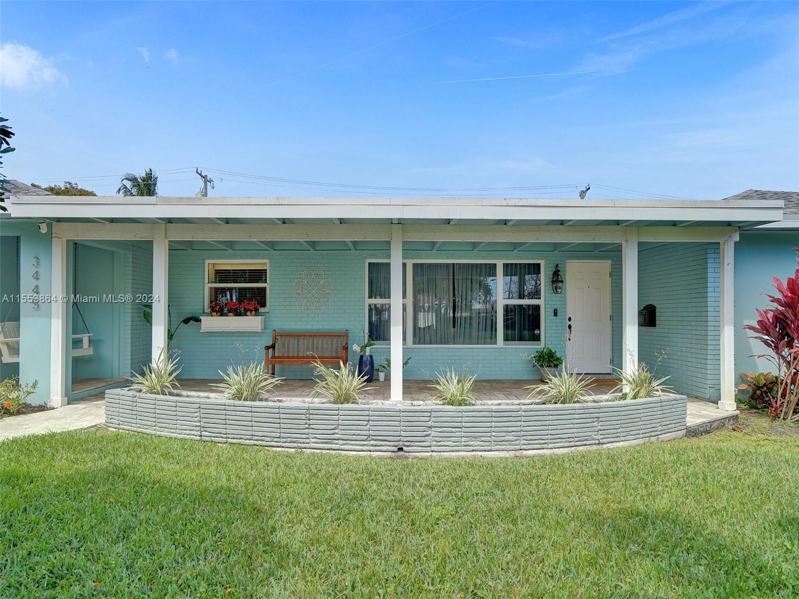 3445 Fillmore Street Hollywood, FL 33021 - Photo 3 of 76 a front view of a house with a yard and seating space