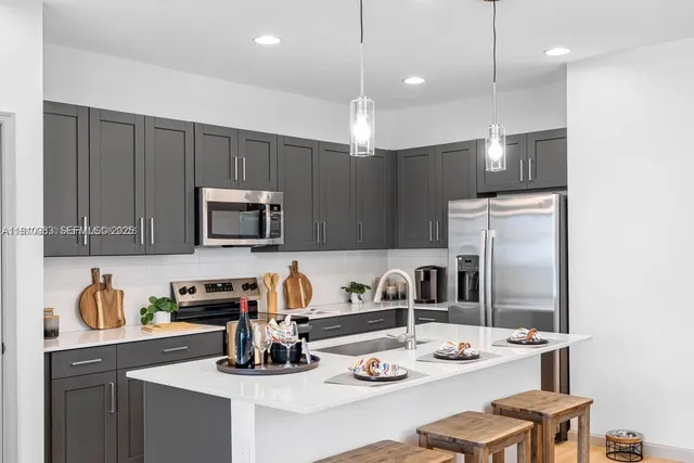 a kitchen with a sink a stove and chairs